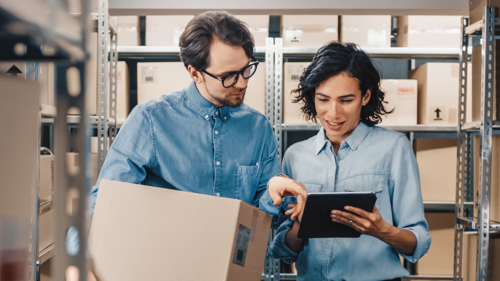 Recall InfoLink two people in warehouse looking at a tablet.