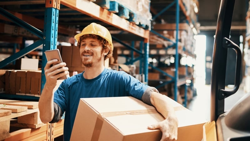 Recall InfoLink recall responder looking at a phone in a warehouse